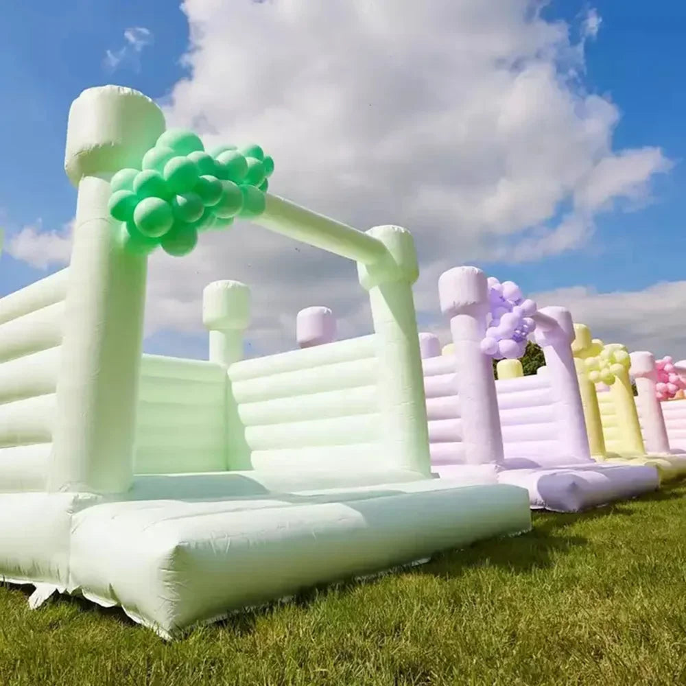 Château gonflable pastel installé pour une fête d'anniversaire en extérieur