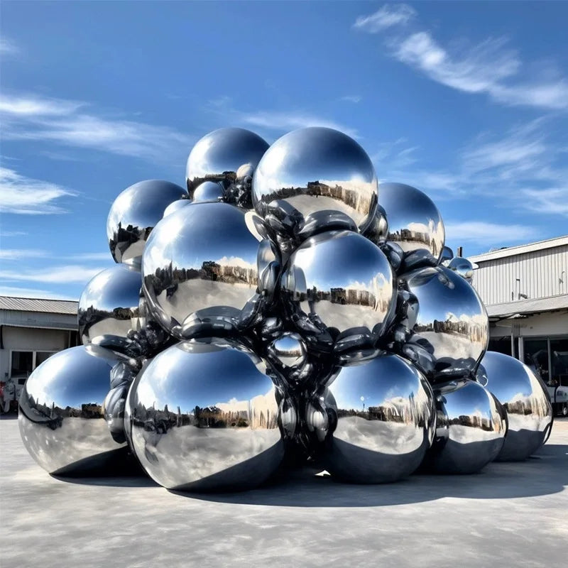 Boule miroir gonflable noire et argentée posée sur une scène