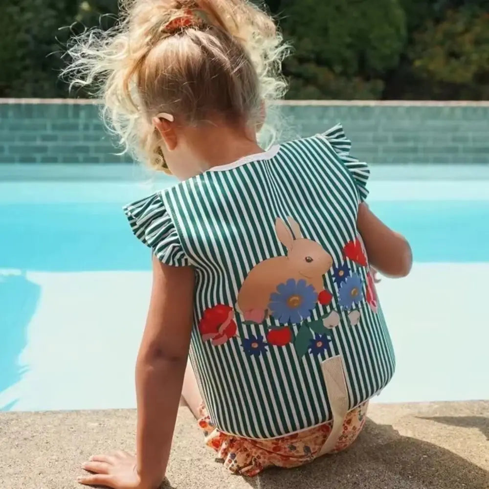 Bébé portant le gilet de flottaison en piscine