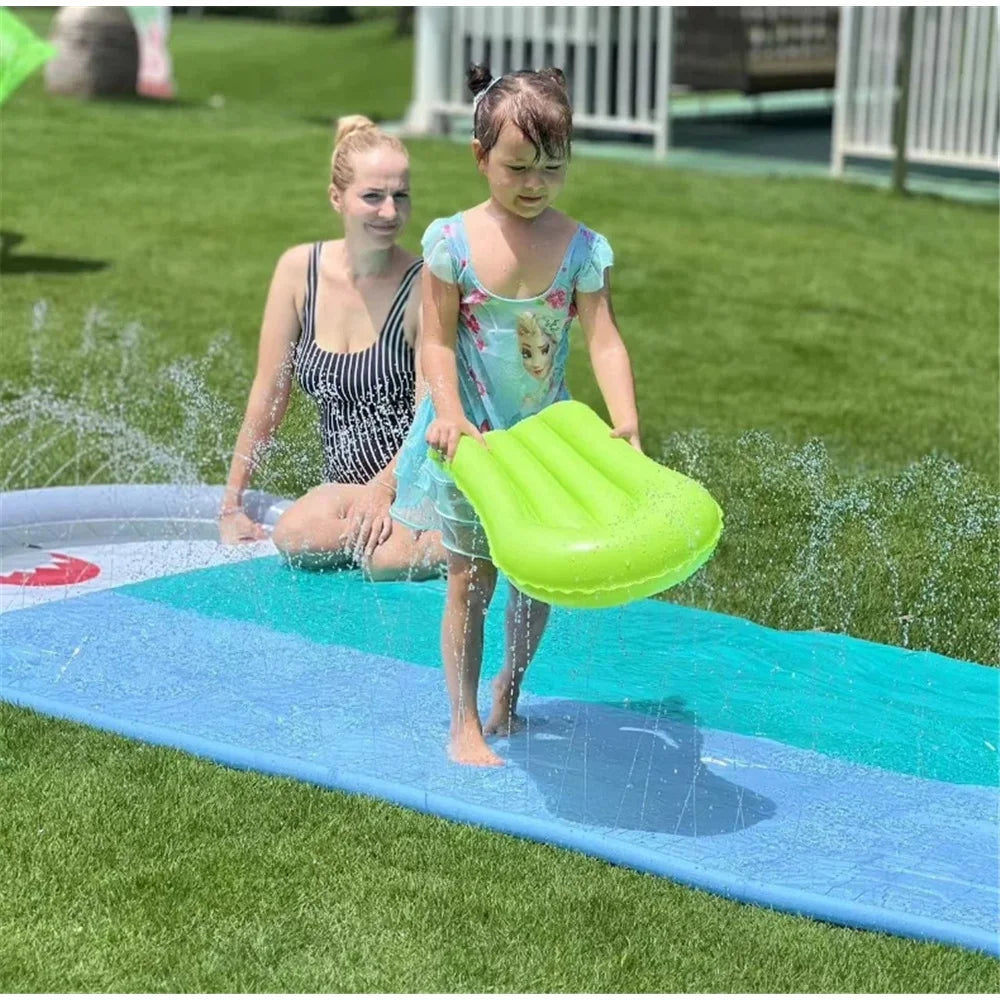 Enfants jouant à deux sur le toboggan aquatique gonflable requin